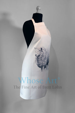 Sheep art apron featuring a sheep drawing, pictured from the left. Hanging on a mannequin.