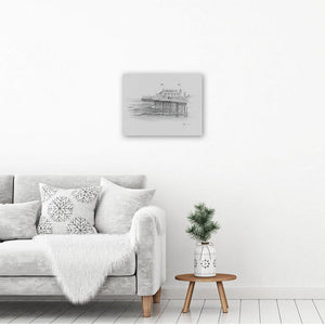 Brighton pier art drawing printed in black and white on canvas and hanging in an interior design setting. The decor is white.