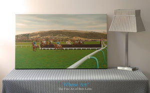 Canvas wall art depicting Cheltenham Racecourse during a National Hunt meeting. Horses jump the 13th fence and race home. 