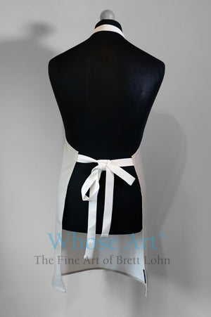 Cotton fine art apron, pictured from the rear, showing apron straps tied in a bow. Apron hangs on a mannequin.