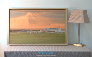 Epsom racing wall art print of a horse race beneath a stormy sunset sky in July. Framed in gold & leaning against a wall.
