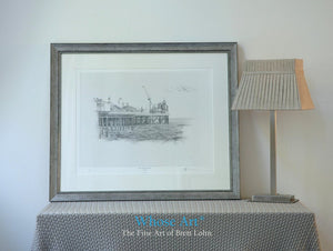 A black and white art print framed in silver, showing a pencil drawing of the Palace Pier in Brighton with the fairground on view