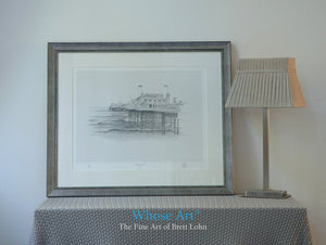 A framed Brighton pier wall art print showing a pencil drawing of the front of the Palace Pier as it rises from the sea.