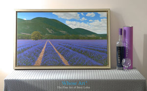 Lavender wall art canvas depicting French lavender fields in Provence. Canvas print is framed and sitting on a table by a lamp
