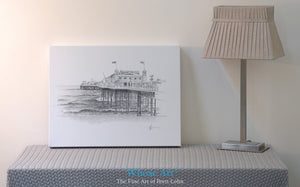 Wall art canvas print of the Palace Pier in Brighton drawn in pencil on paper. This art print sits on a table by a wall.
